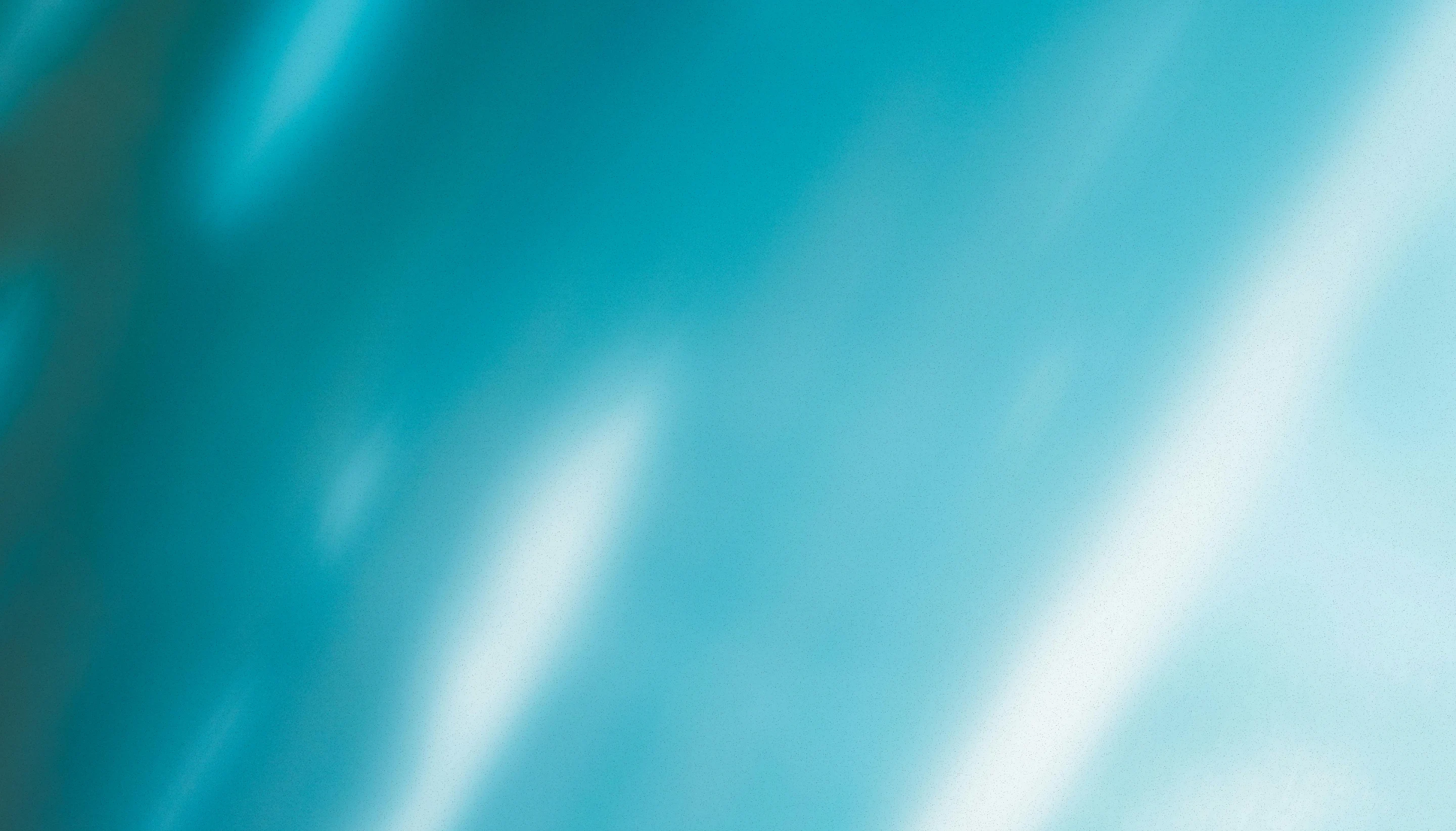 Abstract smooth gradient background with teal and light blue tones blending softly.